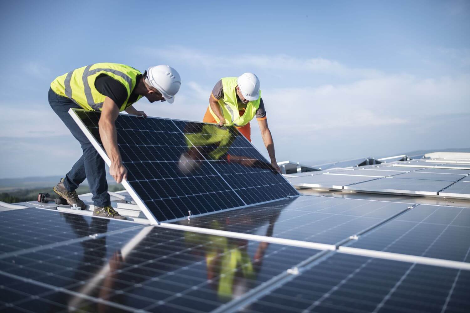 Dois homens instalando placas solares a uma usina solar de investimento